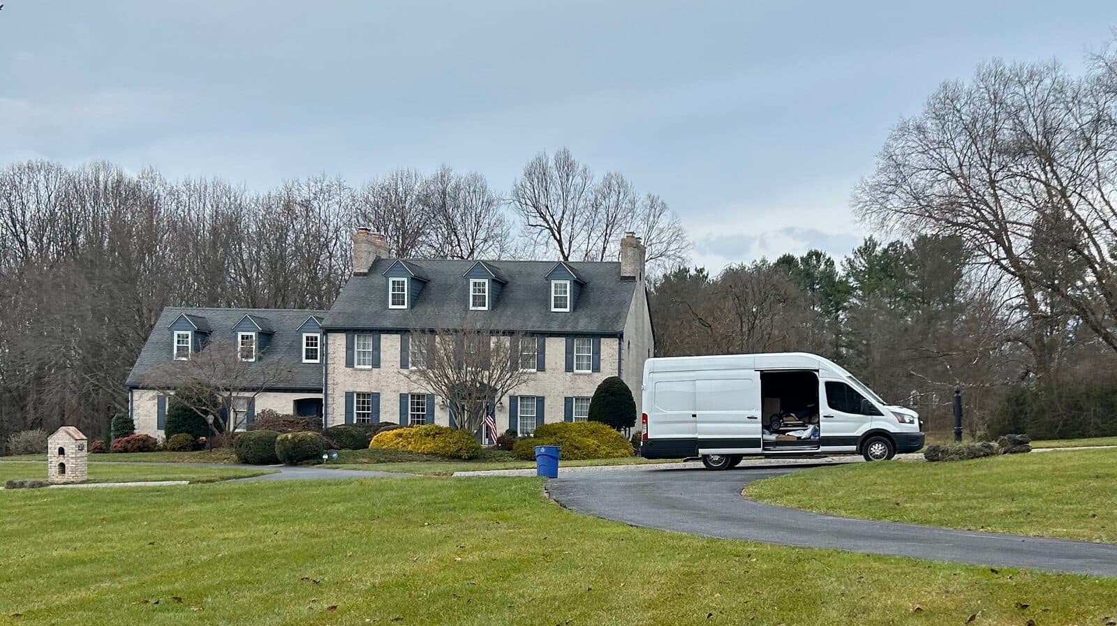 A Cush Moving Company van parked outside a home, ready to load